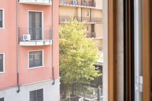 A multi-story building with balconies, a tree in the foreground, and a view through an open window. - Milano Zara Urban Nest (Milan)