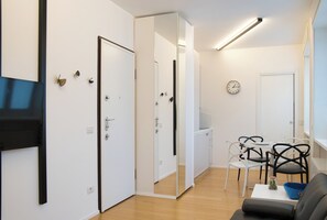 A modern living room with a sofa, chairs, a coffee table, and a dining area with a table and chairs. - Milano Zara Urban Nest (Milan)