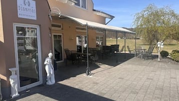 Un restaurante llamado 'Dionysos' con terraza al aire libre y un patio cubierto.