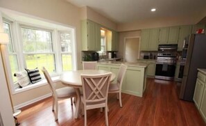 Bright eat-in kitchen with sunny windows, dining for four, and modern appliances