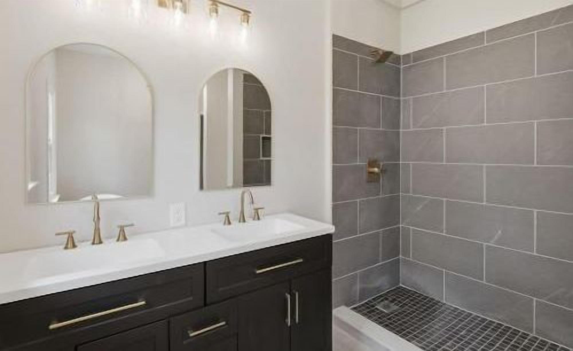 Modern bathroom with double vanity and sleek tiled walk-in shower
