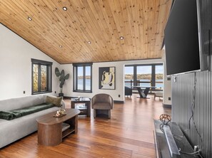 Ein modernes Wohnzimmer mit Holzboden, einer Couch, einem Couchtisch und einem Kamin.