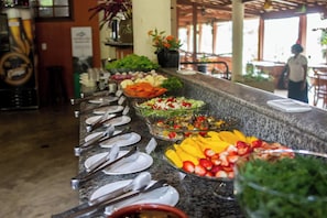 Un comptoir de buffet proposant divers plats et ustensiles.