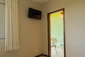 Habitació amb una porta que dona a un balcó amb una cadira i una taula.