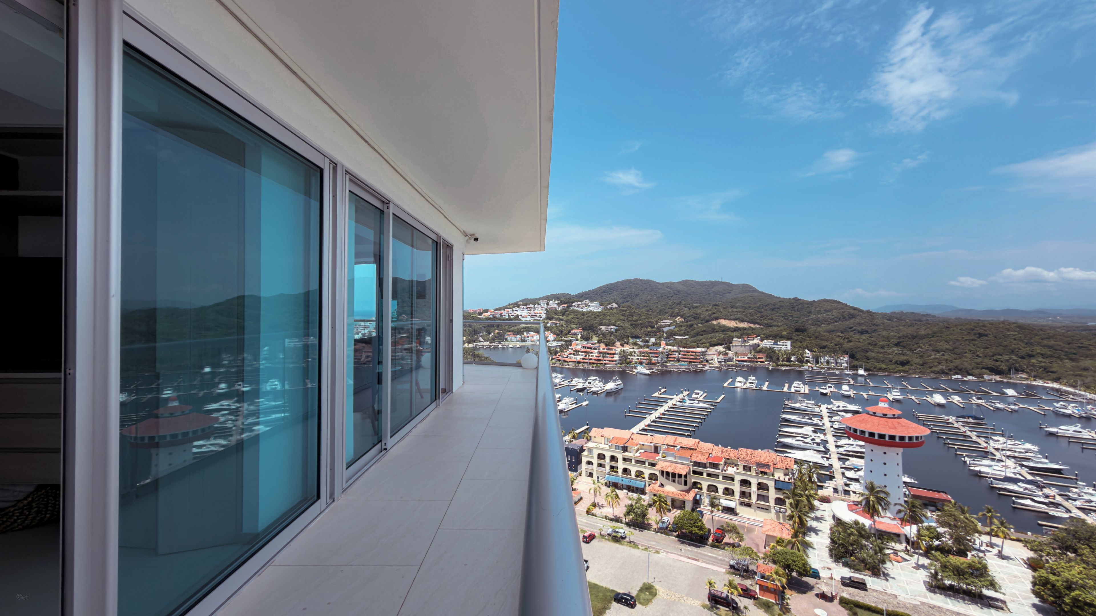 A balcony with a view of a marina and buildings.