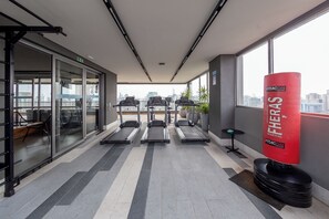 A gym with treadmills, a punching bag, and a view of the city. - Vergueiro by Bhomy (São Paulo)