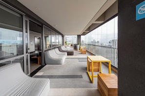 A modern balcony with seating and a view of the cityscape. - Vergueiro by Bhomy (São Paulo)