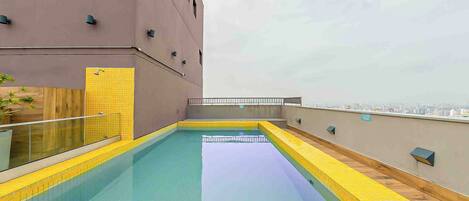 An indoor swimming pool with a view of the city skyline.
