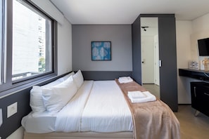 A modern hotel room with a large bed, a painting, a desk, and a television. - Vergueiro by Bhomy (São Paulo)