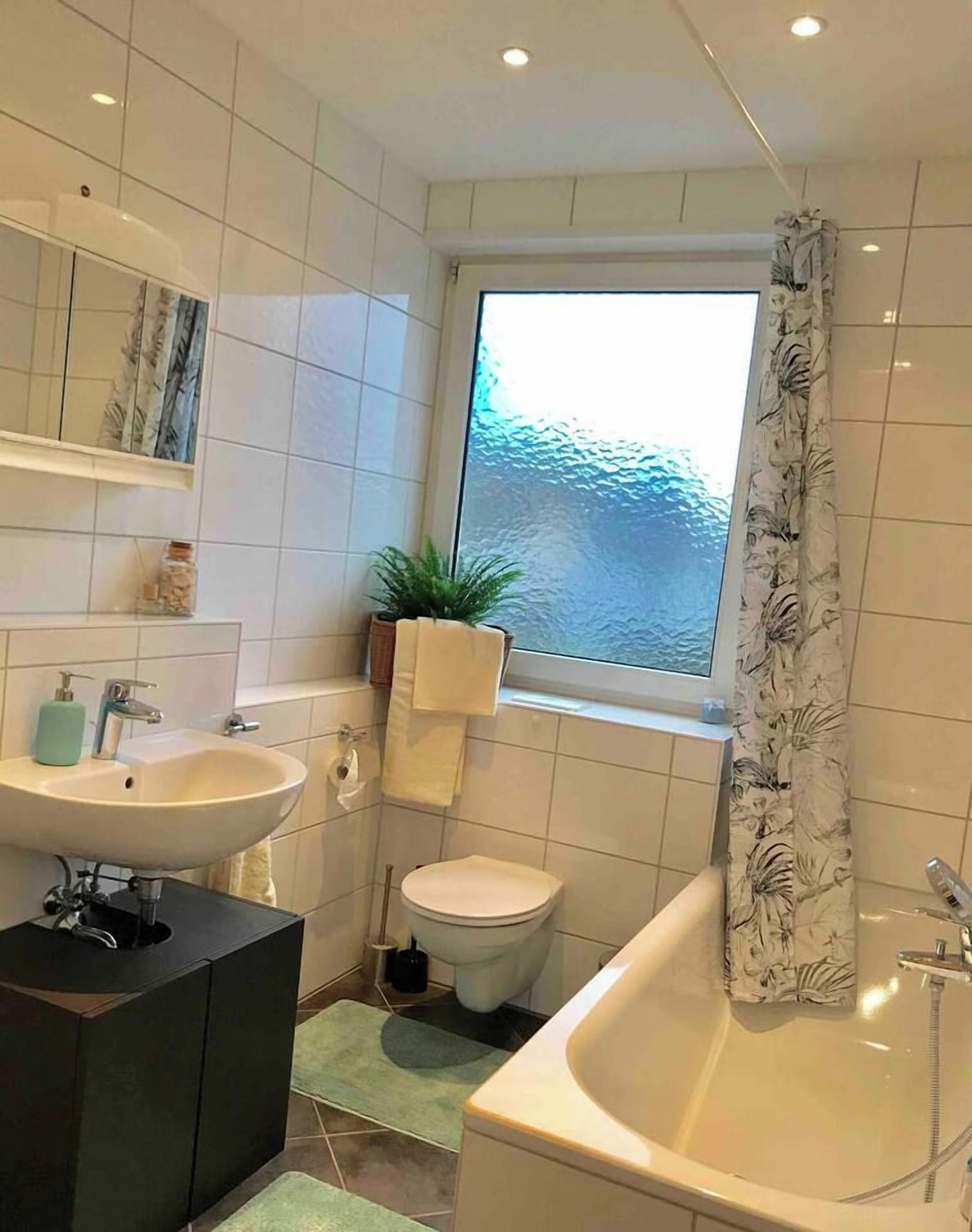 Een badkamer met een wastafel, toilet en bad.