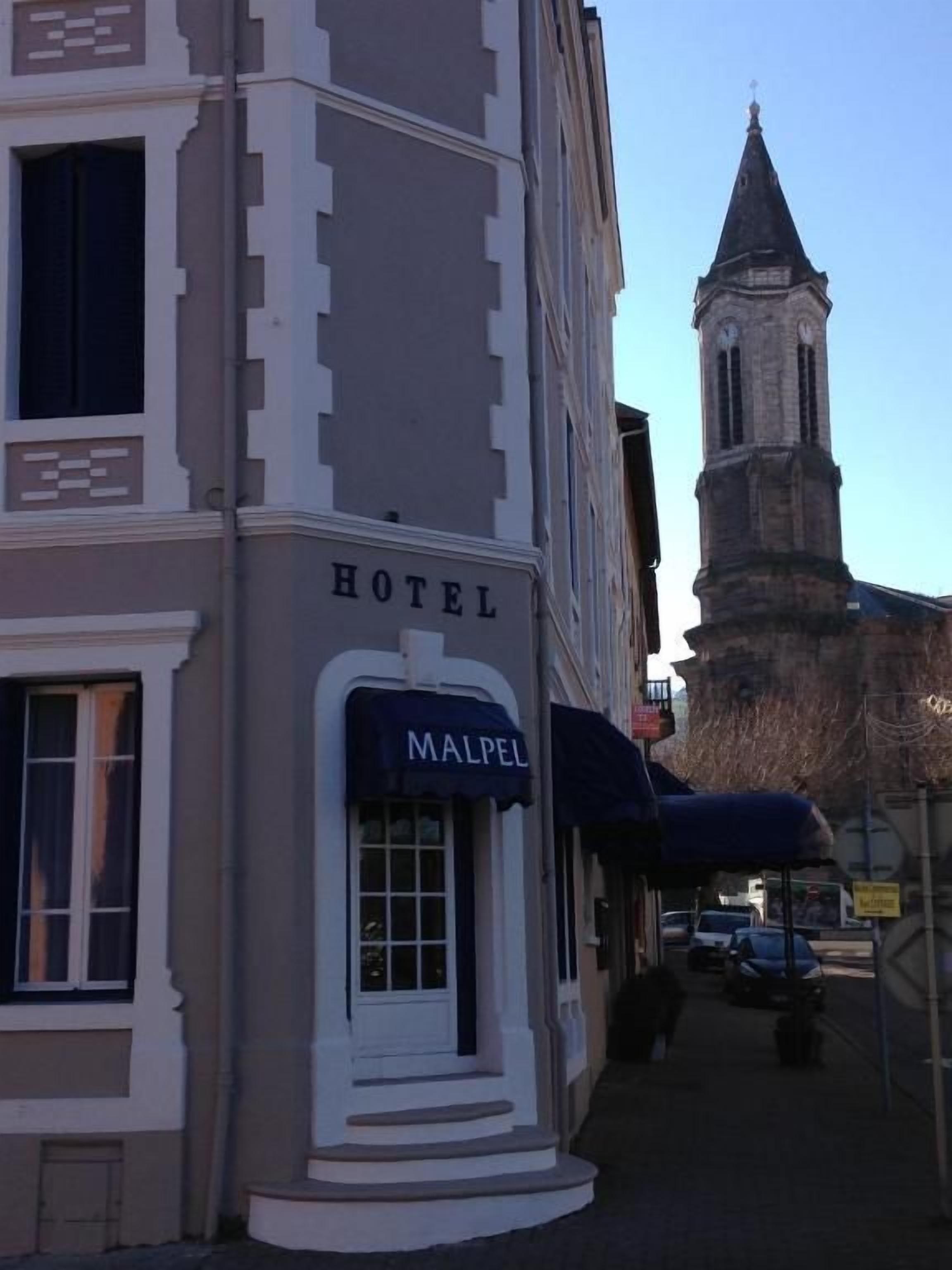 A hotel with a sign labeled 'HOTEL' and a smaller sign for 'MALPEL' in front.