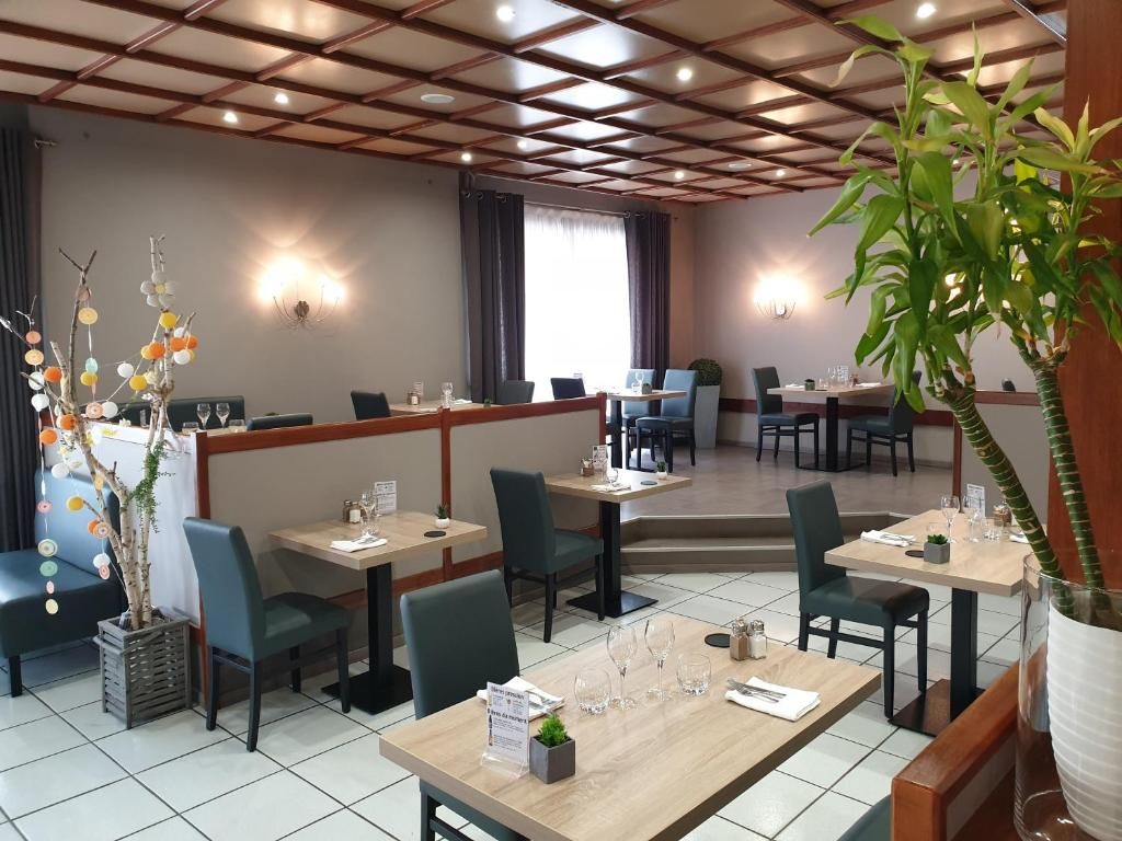 Un restaurante con cabinas y mesas, techo de madera y plantas en macetas.