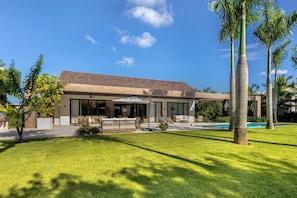 A modern house with a swimming pool, outdoor furniture, and palm trees. - Villa Flamboyan- Wonderful house in enchanting Casa de Campo (Casa de Campo)