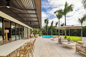 Eine Außenpatio mit Pool, Liegestühlen und Essbereich.