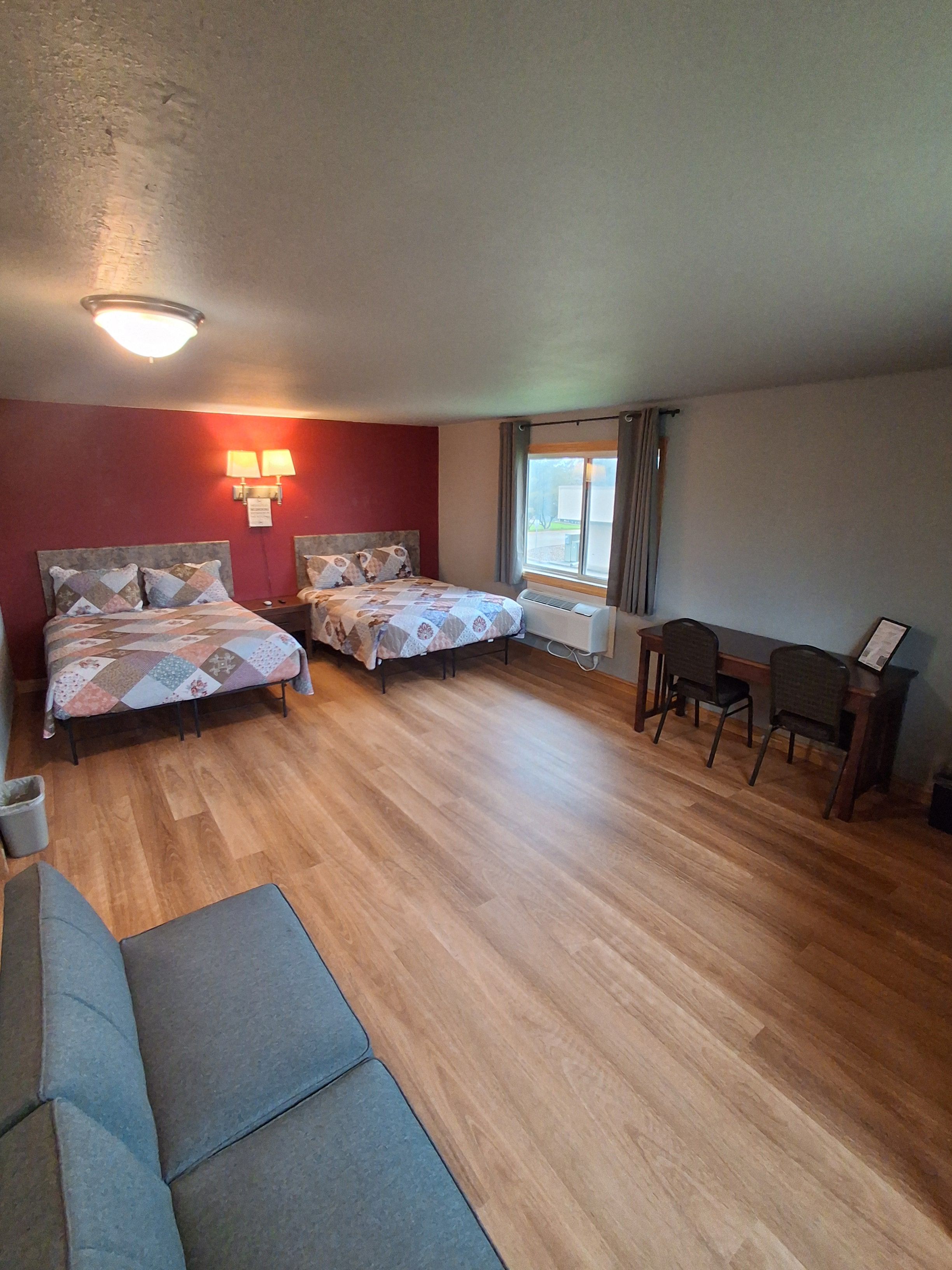 Une chambre avec deux lits, un bureau et une chaise.