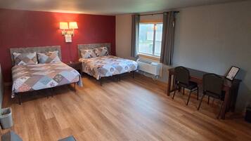 Une chambre avec deux lits, un bureau et une chaise.
