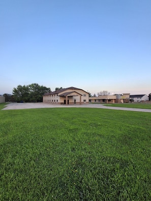 A building with a sign reading 'Cyclone Lodge' in front of a grassy area. - Cyclone Lodge By Fresh Stay (Harlan)