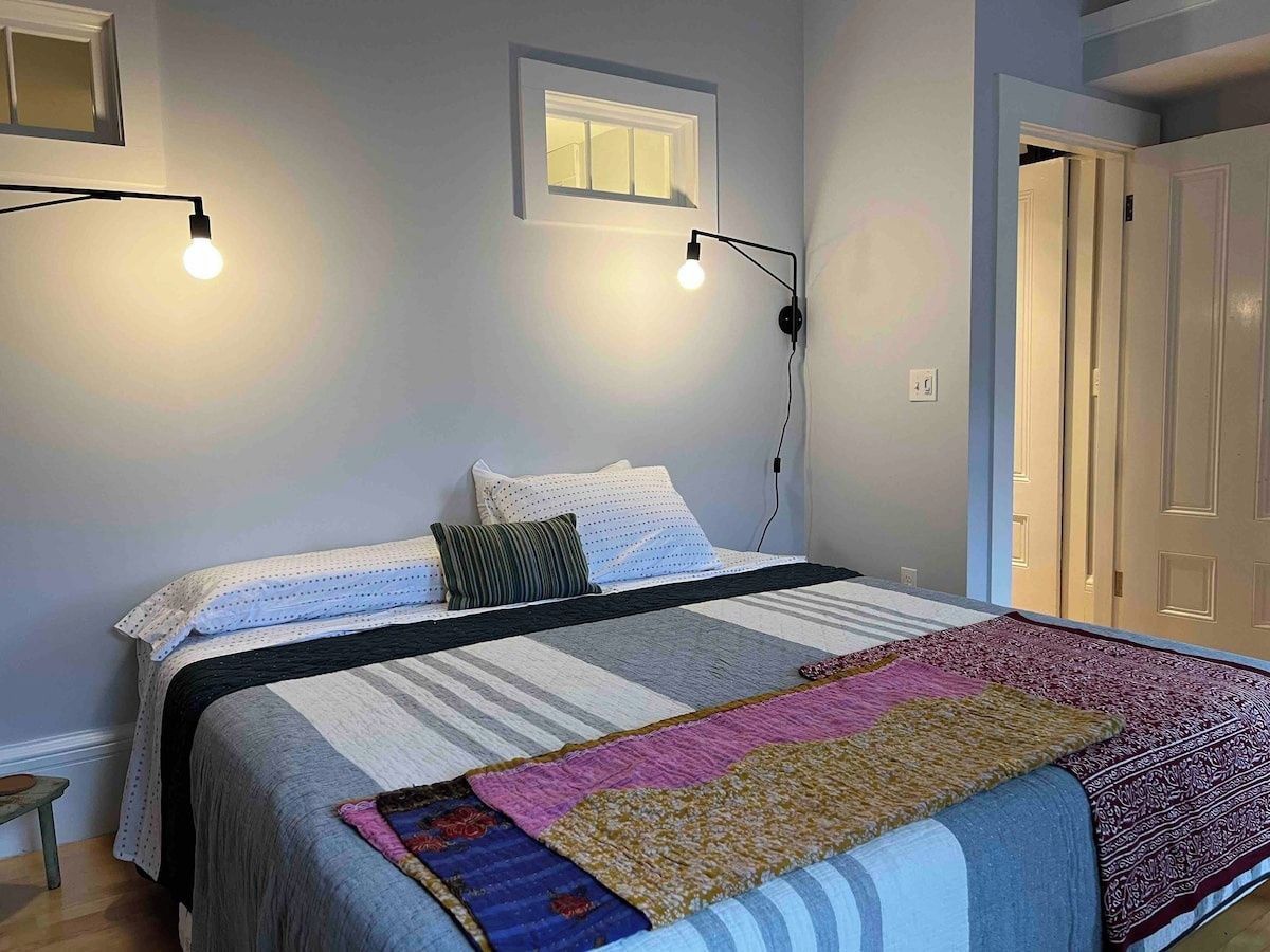 Ein Schlafzimmer mit Bett, Fenster und Tür.