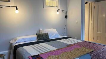 Ein Schlafzimmer mit Bett, Fenster und Tür.