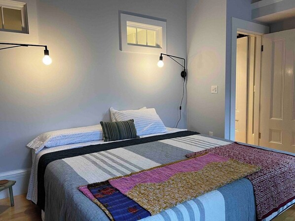 Ein Schlafzimmer mit Bett, Fenster und Tür.