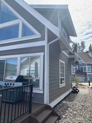 A two-story house with a visible deck area and a grill.