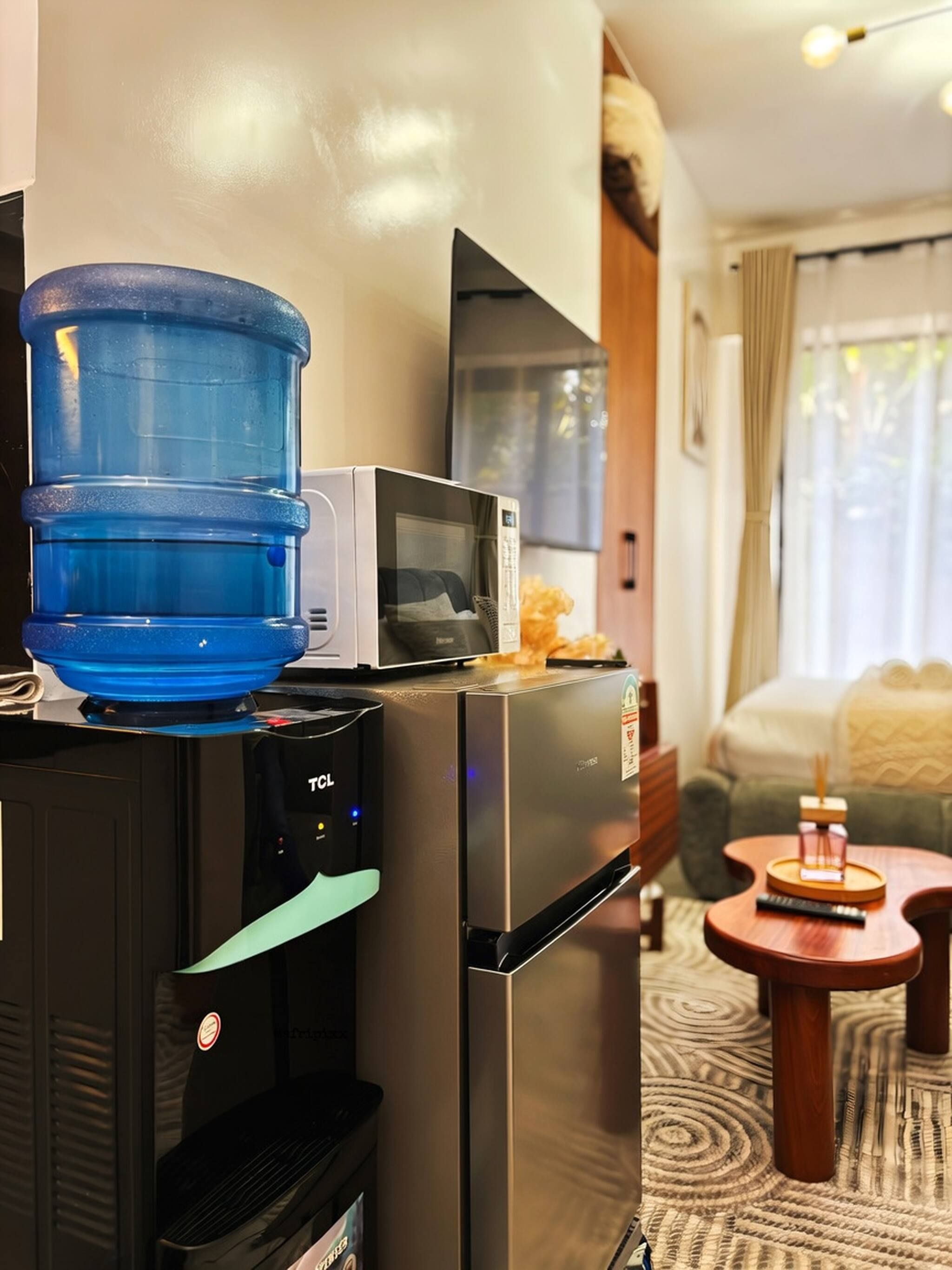 A compact kitchenette with a microwave, a water dispenser, and a small refrigerator.