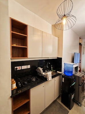 A compact kitchen with a gas stove, a microwave, and a water dispenser. - Studio, Kiambu Road, Nairobi (Nairobi)