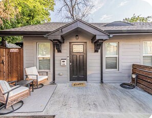 Ein Haus mit Veranda, einer Tür und einer Bank.