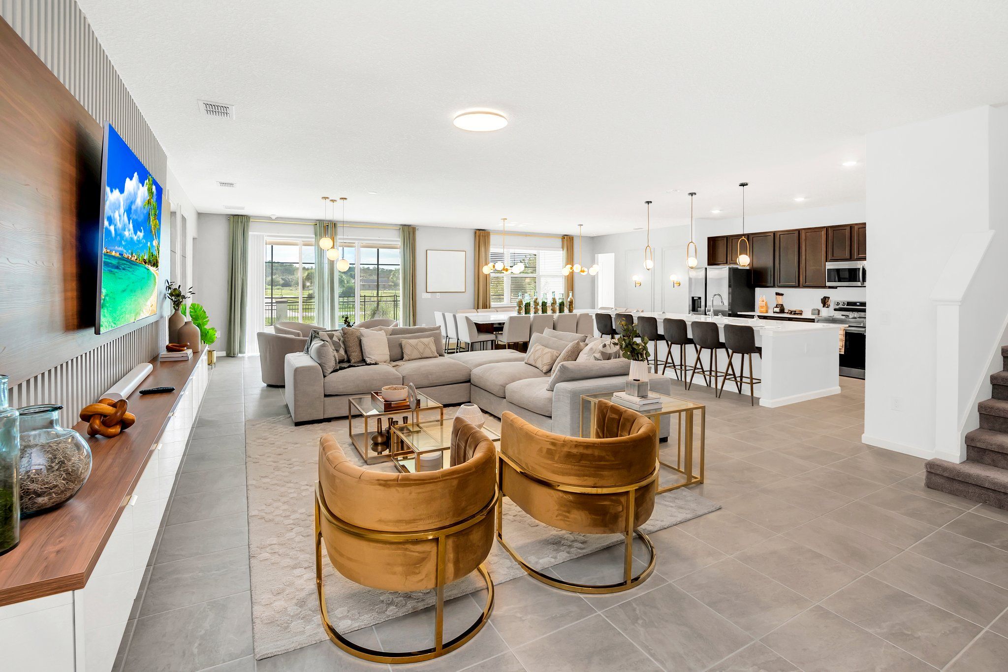 A modern living room with a sectional sofa, a dining area, and a kitchen.