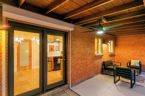 Une cuisine moderne dotée d’une grande fenêtre, d’un coin repas avec un banc et d’un ventilateur de plafond.