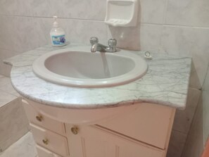 A bathroom with a marble sink, a soap dispenser, and a soap dish. - Port Antonio Residence House in Port Antonio (Port Antonio)
