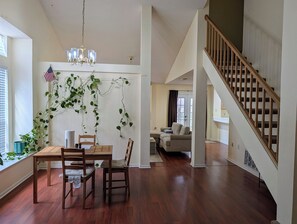 Un vaste espace de vie comprenant une table à manger, des chaises et un escalier.