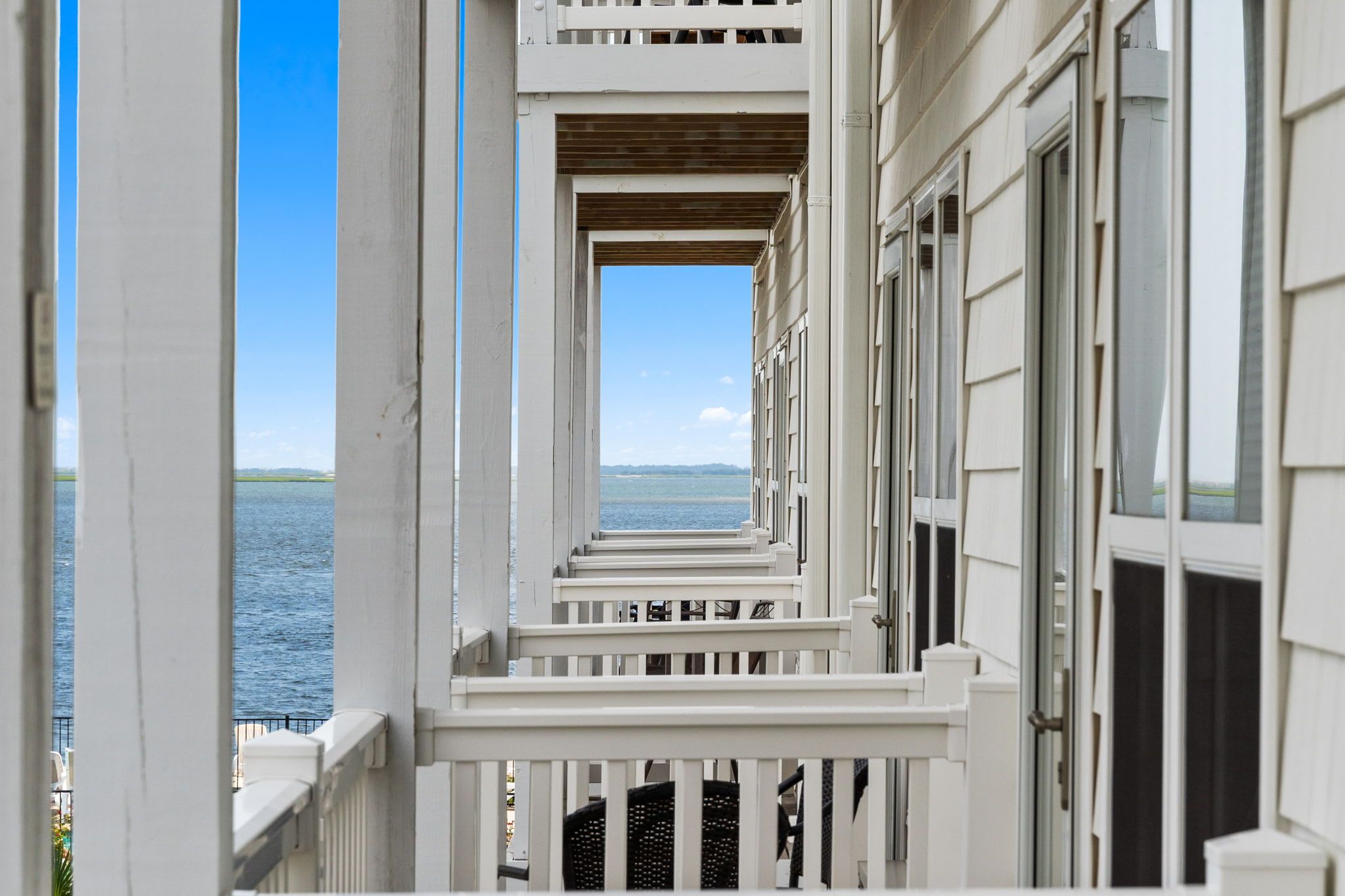 A balcony with a view of the sea and a clear sky.