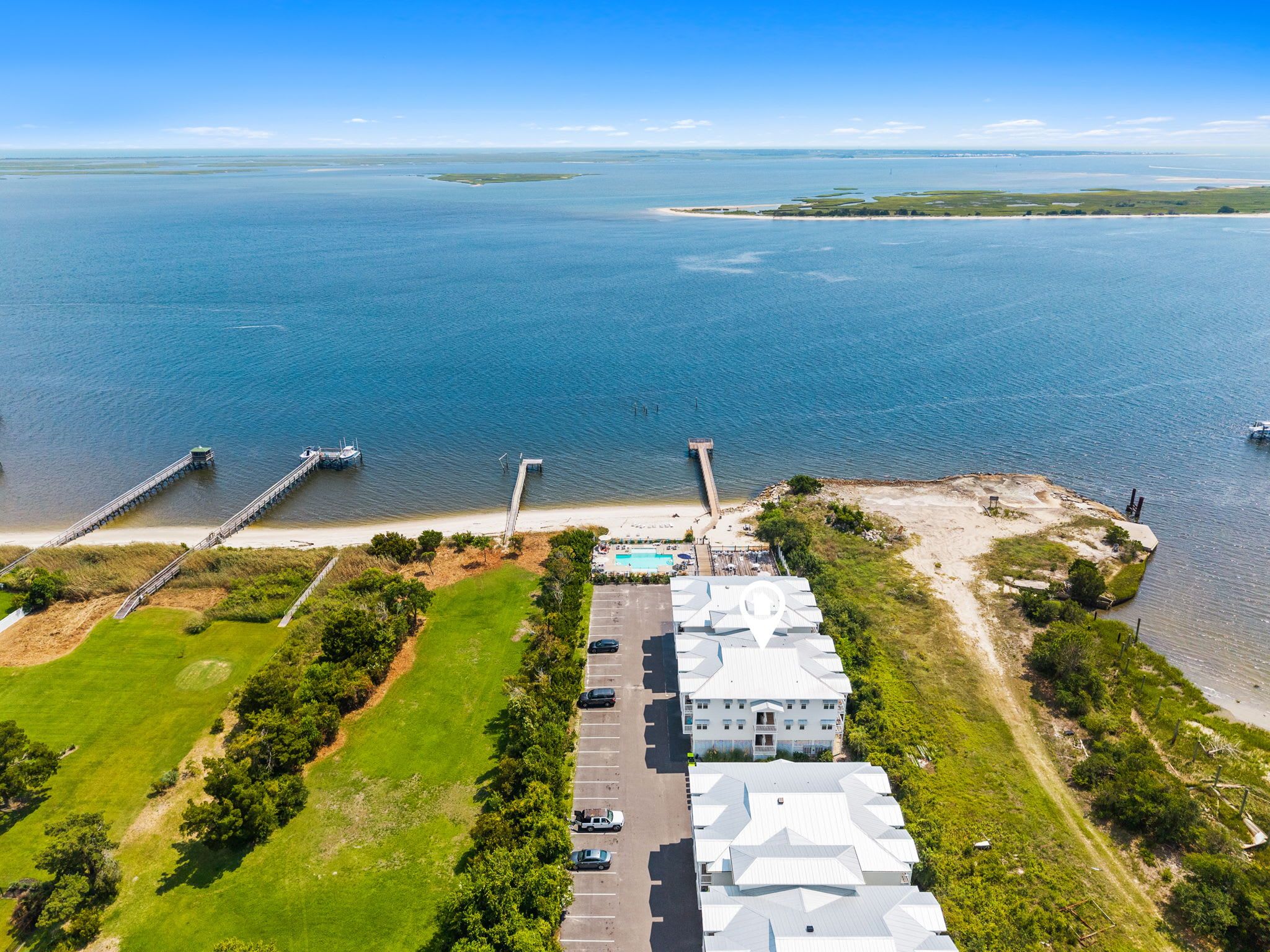 Una propiedad costera con un puerto deportivo, piscina y un edificio grande con múltiples habitaciones.