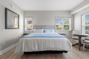 Une chambre à coucher comprenant un lit, des tables de chevet, un bureau et une chaise.