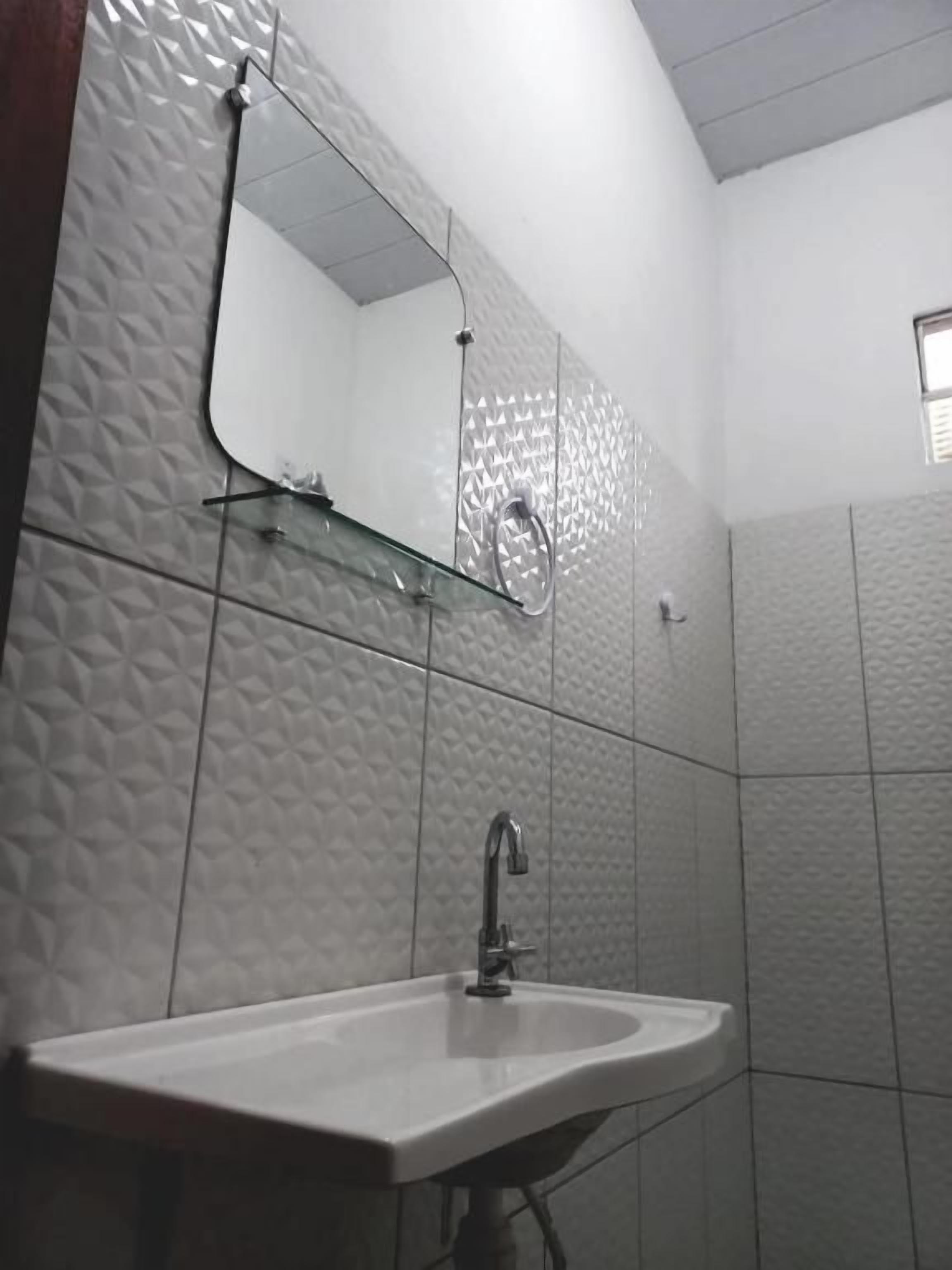 Une salle de bain avec un lavabo, un miroir et une douche.