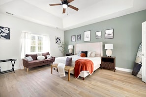 A bedroom with a bed, a sofa, a chair, a nightstand, a floor lamp, and a ceiling fan. - Casa Oasis Bonaire · 3 Kings · Fireplace · Gym (Bonaire)