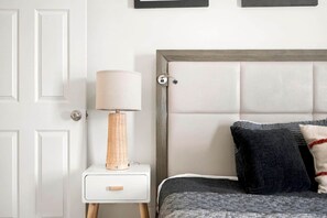 Una camera da letto con un letto, un comodino con una lampada e una porta.