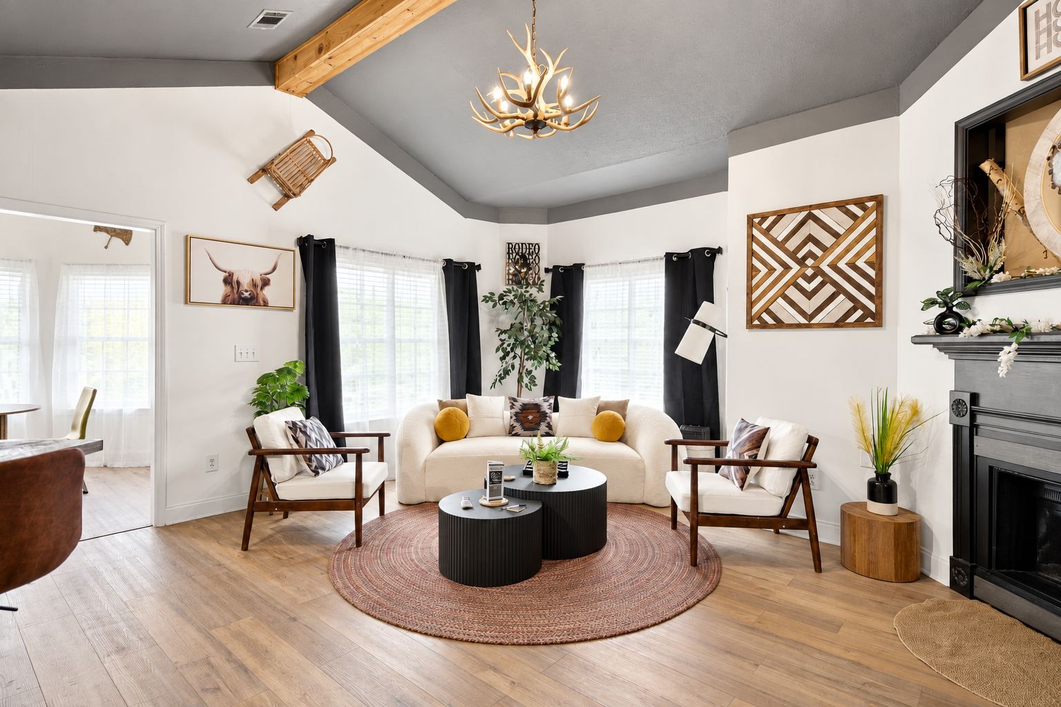 A modern living room with a fireplace, a round coffee table, and a sofa with cushions.