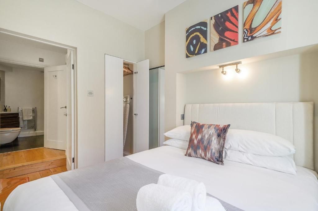 Una habitación de hotel con una cama, un baño con bañera y una puerta que da a otra habitación.