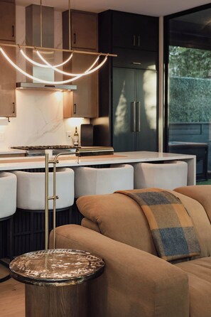A modern kitchen with a central island, bar stools, and a dining area. - Luxury SoCo Haven w/ 6Sleep, Hot Tub & Gym (Austin)