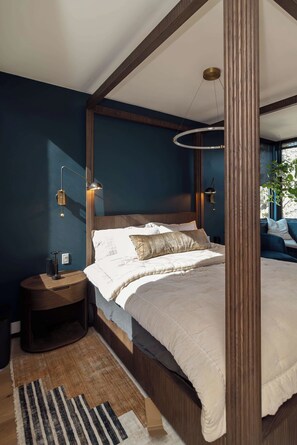 A bedroom with a four-poster bed, bedside lamps, a rug, and a view of the outdoors. - Luxury SoCo Haven w/ 6Sleep, Hot Tub & Gym (Austin)