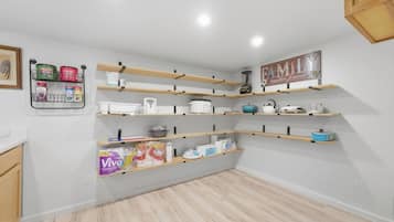 Una cucina con scaffali in legno, un'isola centrale e un ripiano a parete per spezie.