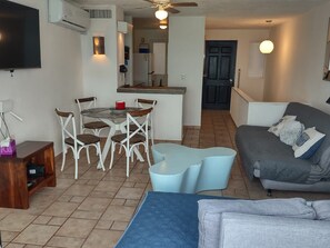 Ein Wohnzimmer mit einer Couch, einem Couchtisch und einem Fernseher.
