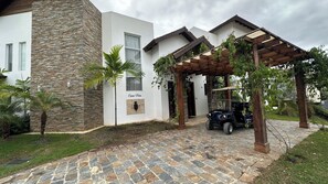Ein modernes Haus mit einer Stein-Fassade, einer überdachten Veranda und einem gepflasterten Einfahrt.
