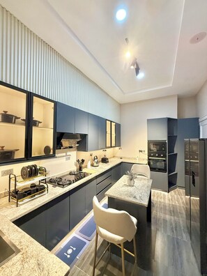 Una cocina moderna con una isla central, electrodomésticos integrados y una zona de estar.