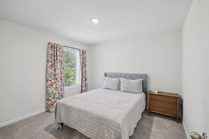 A bedroom with a bed, a nightstand, a window with curtains, and a ceiling light. - Courtside Manor, 5BR Across from Berry Tennis (Rome)
