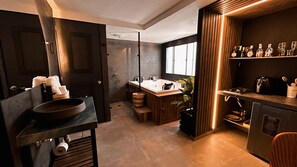 Ein modernes Badezimmer mit einer großen Badewanne, einer separaten Duschkabine und einem Waschtisch mit Spüle.