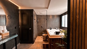Een moderne badkamer met een glazen douchecabine, een houten wastafelmeubel en een groot raam voor natuurlijk licht.