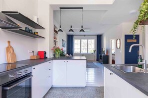 A modern kitchen with a central island, built-in appliances, and pendant lighting. - Design Apart 1 BR/Pankow-P. Berg/Netflix/Parking (Berlin-Bezirk Pankow)